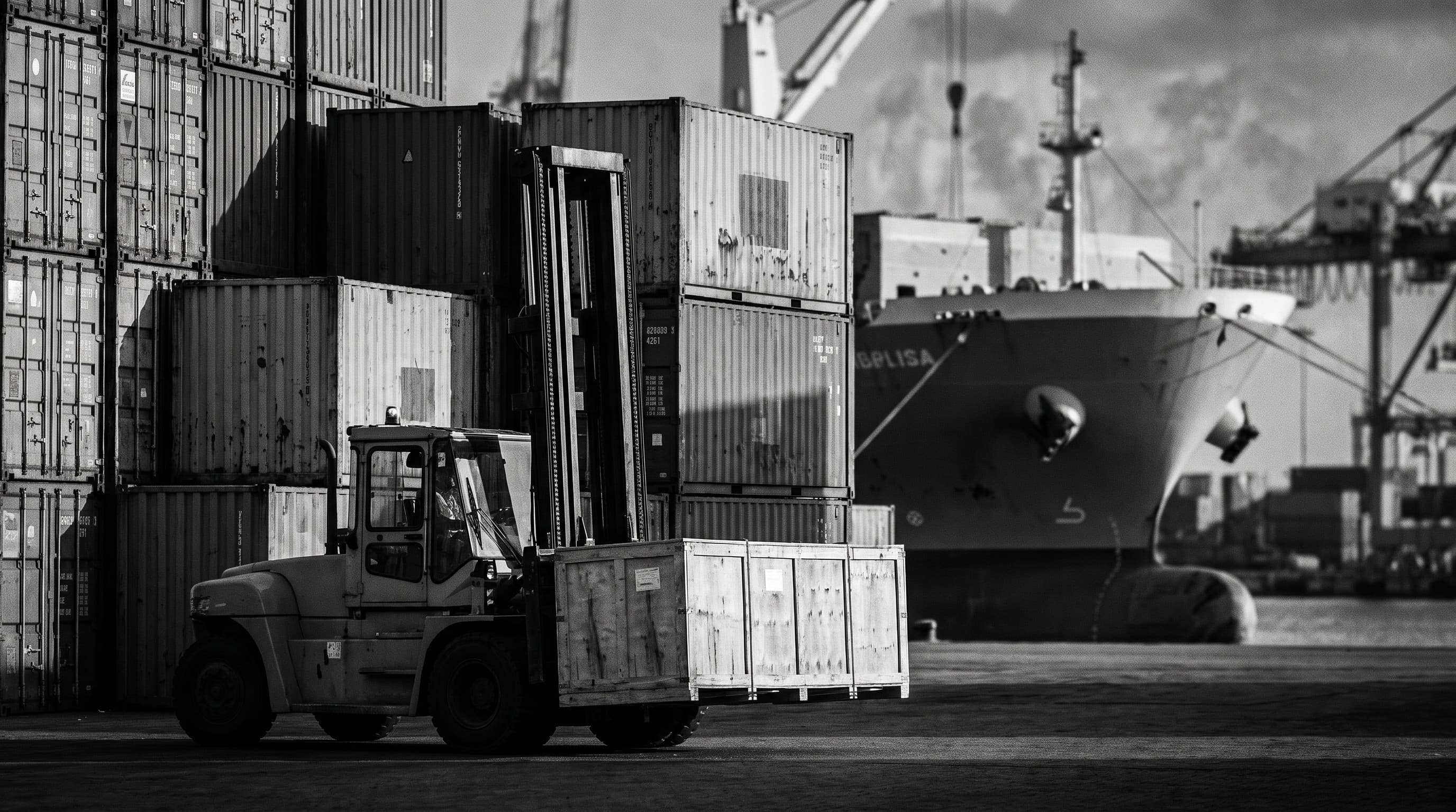 Conteneurs et navire au port, chariot élévateur déplaçant une caisse en bois — fret maritime vers la Guinée.